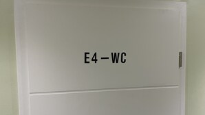 A white door with the label "E4-WC" indicating a room or area. - Pension Waldau (Kassel)