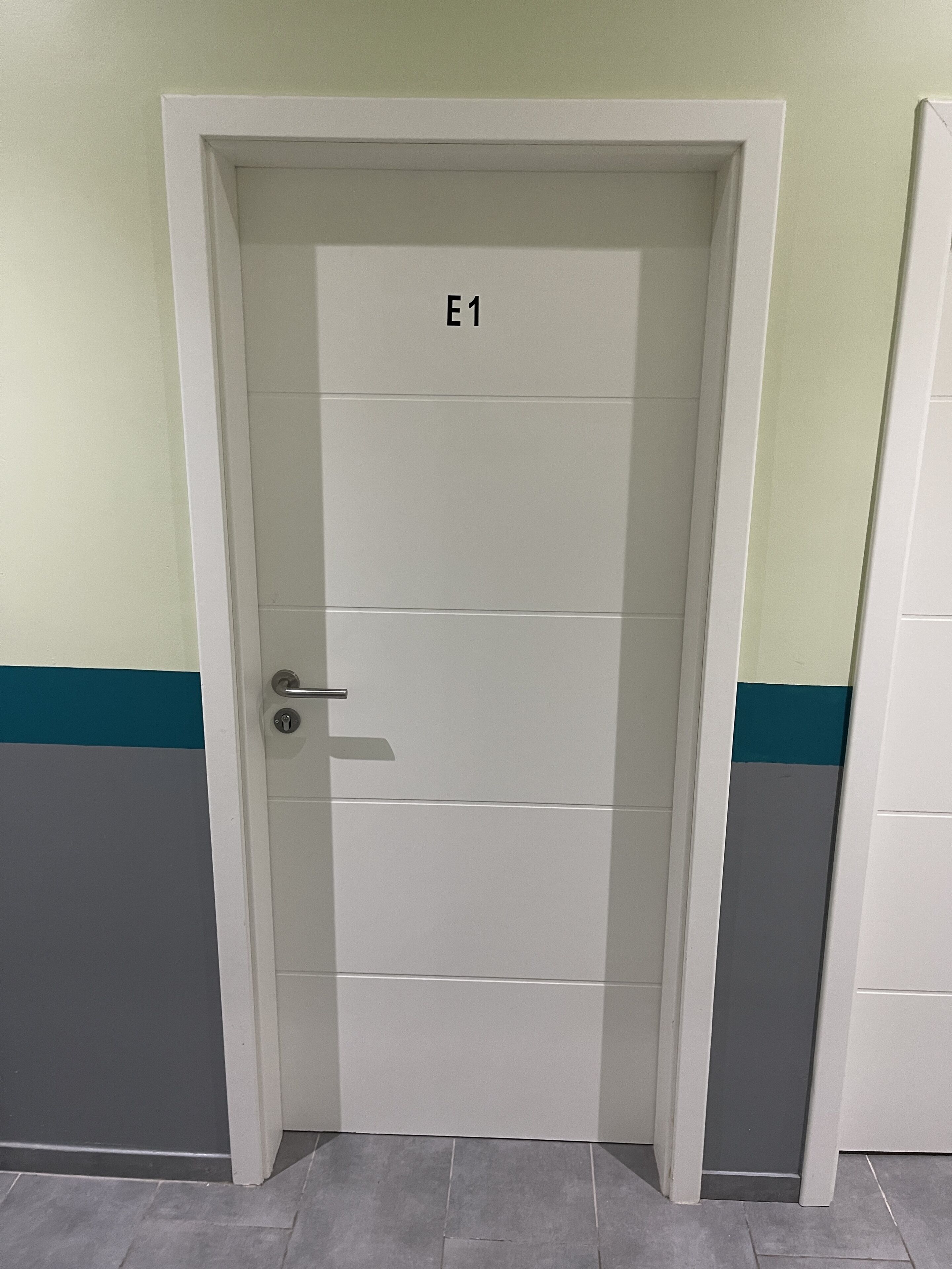 A closed door with a handle, marked with the label "E1".