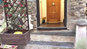 Un edificio de piedra con puerta de madera, número 5, y escalones que conducen a la entrada.