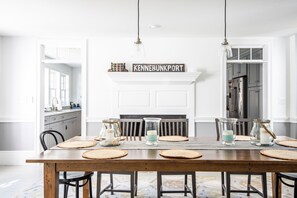 Enjoy meals in this cozy dining area with a fireplace, featuring a wooden table set for four.
