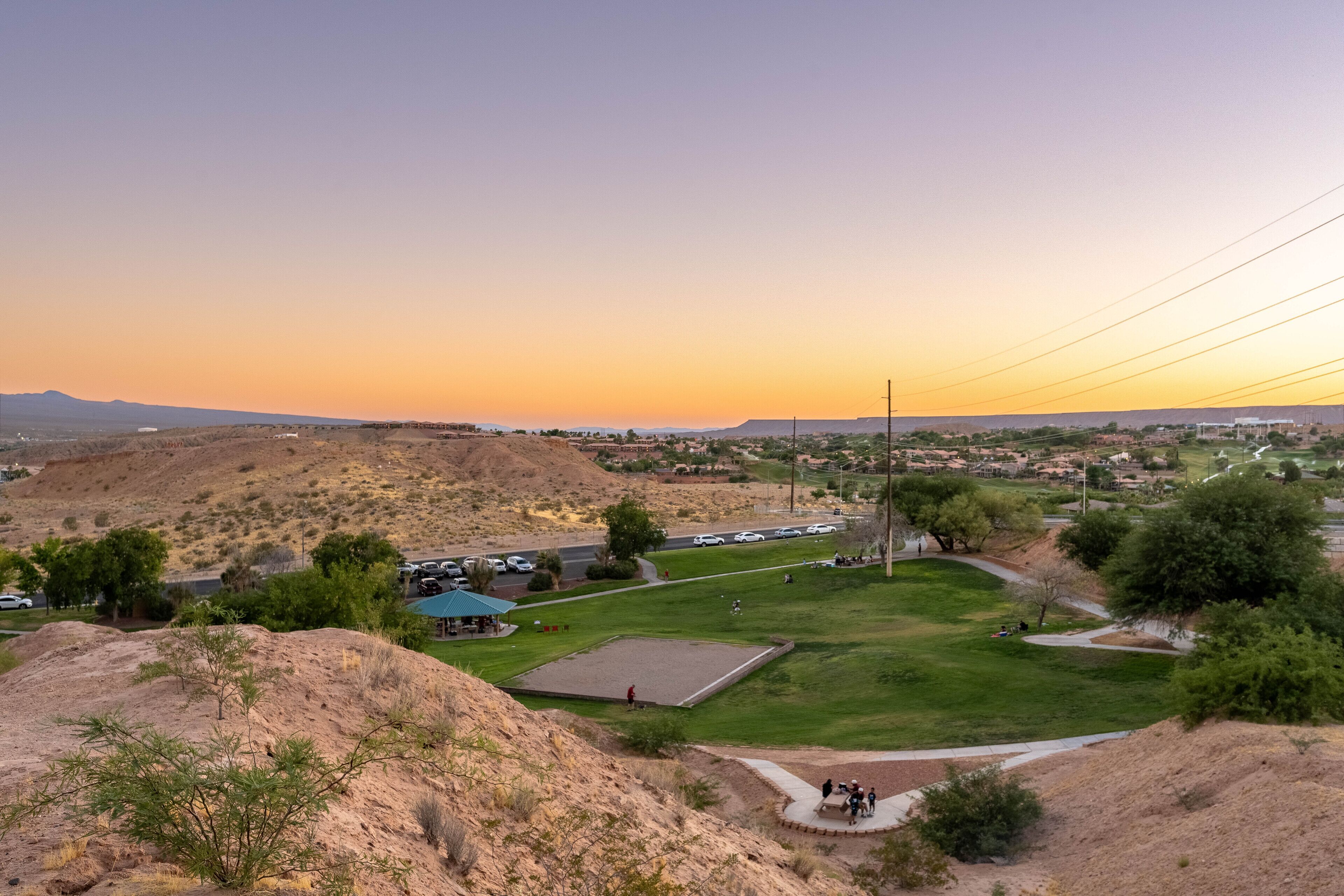 A park with a playground, picnic area, and a large open field.