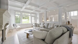 Ein geräumiges Wohnzimmer mit einer großen Eckcouch, einem Couchtisch und einem Kamin.