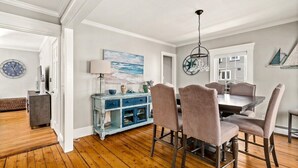 A dining area with a wooden floor, a blue cabinet, and a table with chairs. - Beautiful Beach Cottage in Downtown Bristol (Bristol)