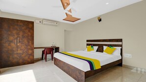 A bedroom with a large bed, a desk, and a wardrobe. - Itsy Hotels Kattari Komforts, Chikmagalur (Chikkamagaluru)