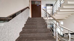 A staircase with a handrail leading to a door marked "Housekeeping." - Itsy Hotels Kattari Komforts, Chikmagalur (Chikkamagaluru)