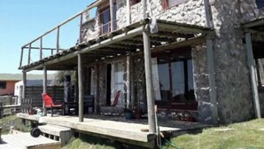 A stone building with a balcony and a satellite dish. - Chalet frente al  mar  Sta Monica  J Ignacio (Jose Ignacio Sta Monica)