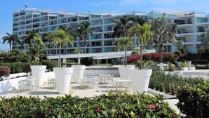 A hotel with multiple floors, outdoor seating areas, and palm trees. - CONDO ARIAN  BY TRVL2HM (Bucerías)