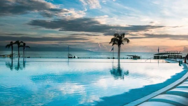 A pool with a view of the ocean and a sunset. - CONDO ARIAN  BY TRVL2HM (Bucerías)