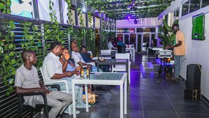 Um espaço moderno em ambiente interno com disposição de assentos e equipamento de DJ.