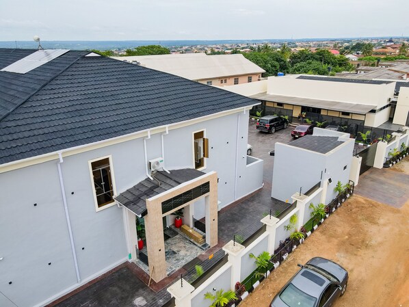 A residential area with modern houses, a paved driveway, and parked cars. - Beniks Courtyard Hotel (Ilorin)