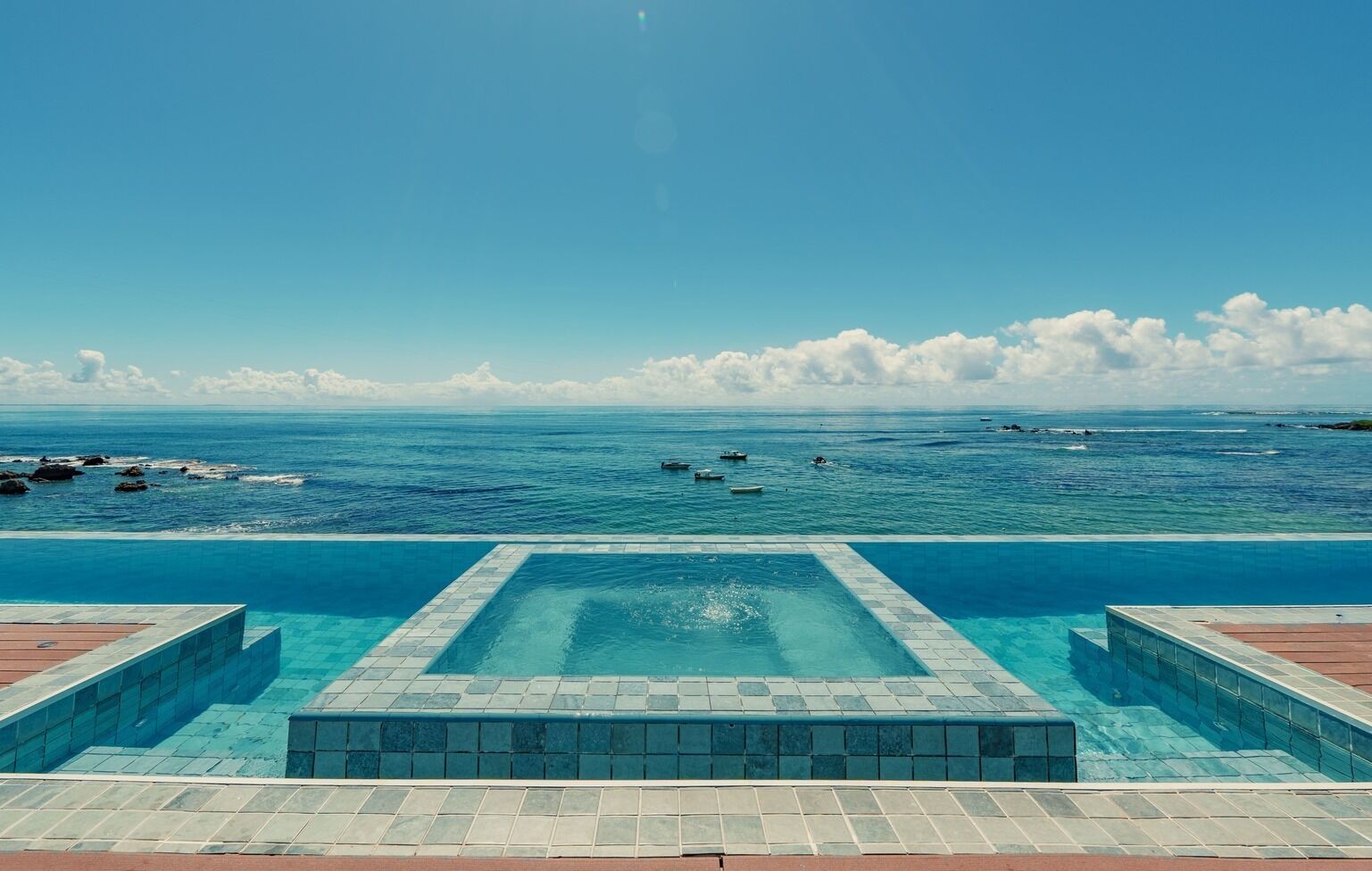 Una piscina con vistas al océano y barcos.