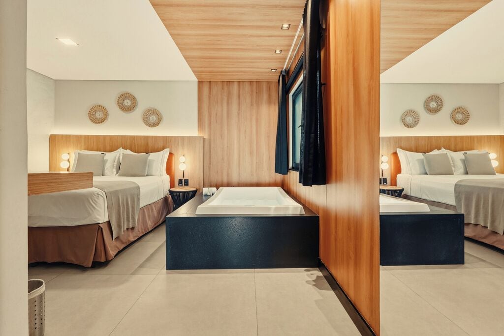 Ein Hotelzimmer mit zwei Betten, einer großen Badewanne, Holzvertäfelung und Wanddekoration.