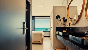 A modern bathroom with a large mirror, two sinks, and a view of the sea. - Pousada Antonella (Cairu)