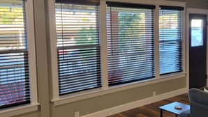 A room with large windows, wooden flooring, and a gray sofa. - Cozy, remodeled townhome retreat in downtown Historic Wallace! (Wallace)