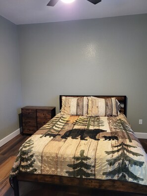 A bedroom with a bed, a nightstand, and a ceiling fan. - Cozy, remodeled townhome retreat in downtown Historic Wallace! (Wallace)