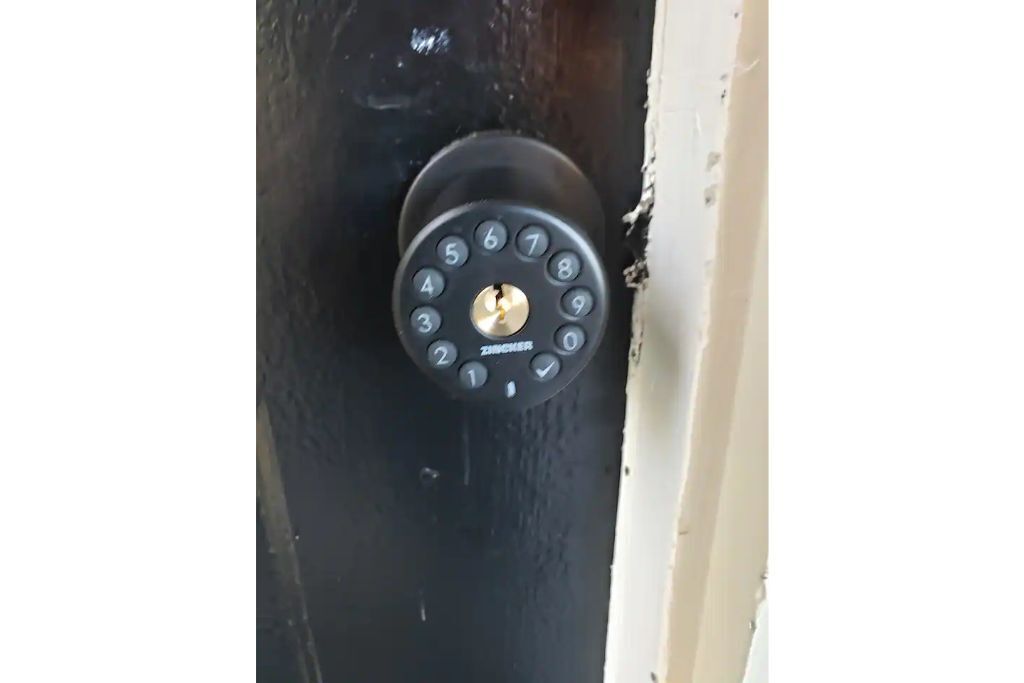 Uma porta com fechadura eletrônica numérica.