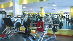 A gym with various exercise equipment, a large mirror, and a clock on the wall. - CONDO T  BY TRVL2HM (Nuevo Nayarit)