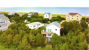 Un quartier résidentiel situé sur la côte, avec des maisons entourées d’une végétation luxuriante et offrant une vue sur l’océan.