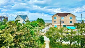 Un quartier résidentiel situé sur la côte, avec des maisons, un sentier et une vue sur la mer.