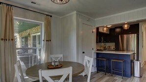 A modern kitchen with a bar area, white cabinetry, and a dining table with chairs. - Golden Bear- lovely one bedroom with fireplace (Sky Valley)