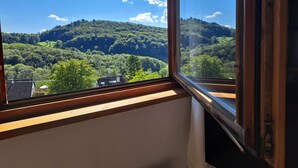 A room with a large window overlooking a forested hillside. - Gemütliche Waldrandlage Badenweiler Sehringen (Badenweiler)