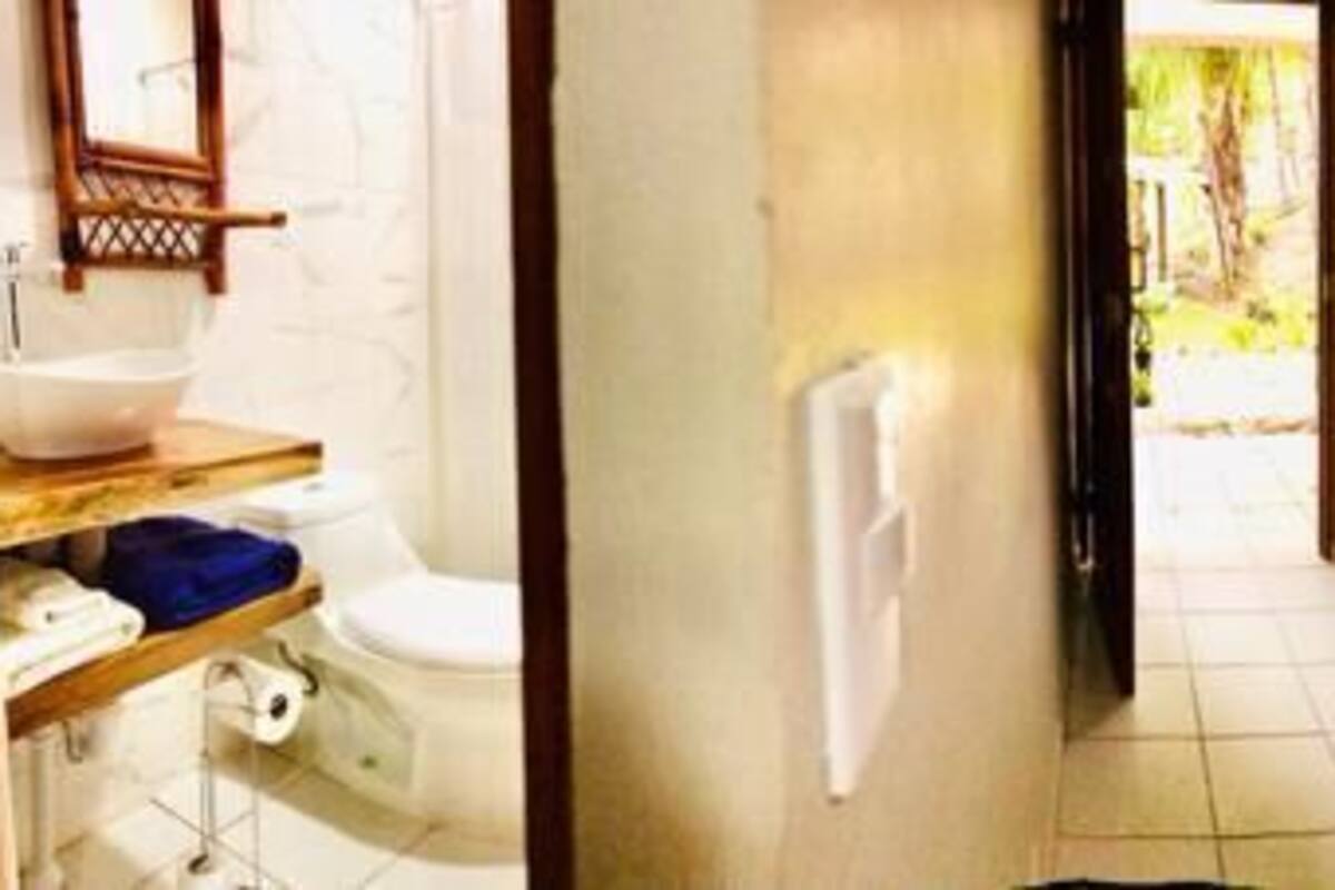 Een hotelkamer met een bed, een bureau met stoel, een televisie en een badkamer.