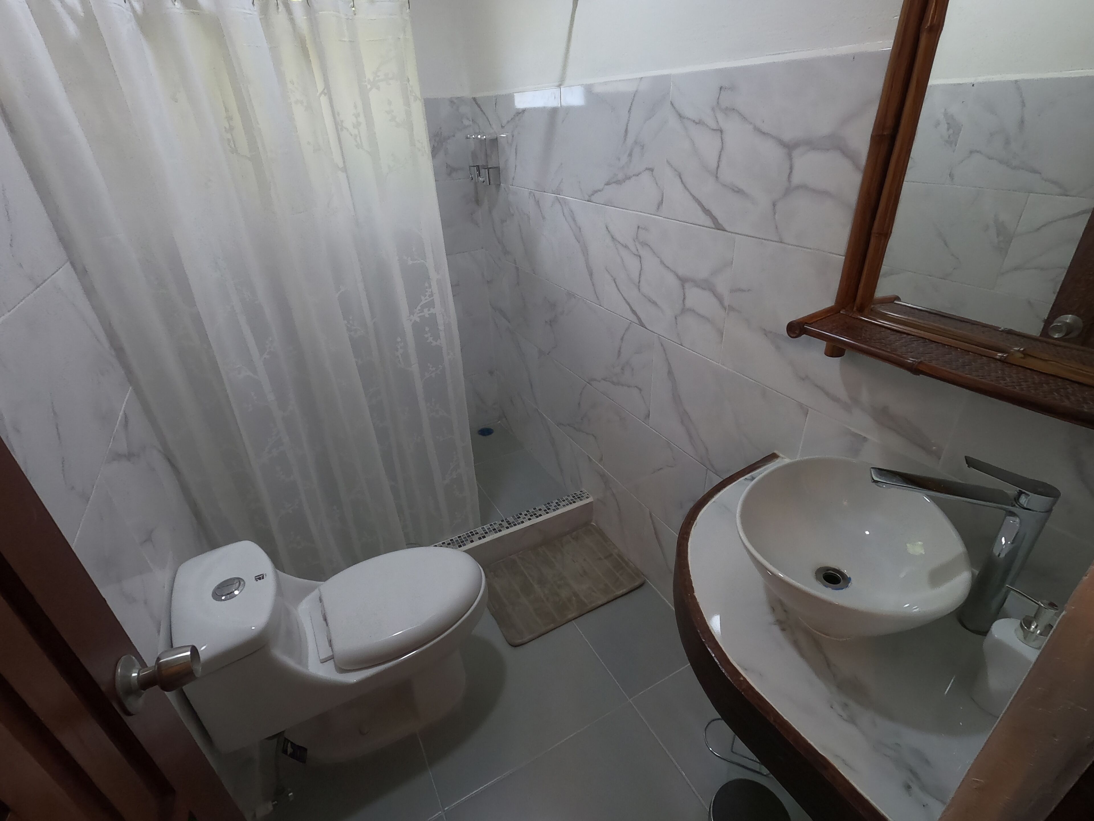 A bathroom with a toilet, sink, and shower.