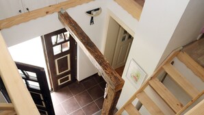 Un escalier en bois offrant une vue sur une pièce située en contrebas.