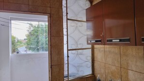 Un baño con ventana, paredes de azulejos y un lavamanos.