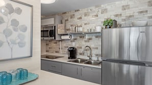 Una cocina moderna con electrodomésticos de acero inoxidable, salpicadero de mármol y una bandeja decorativa azul.