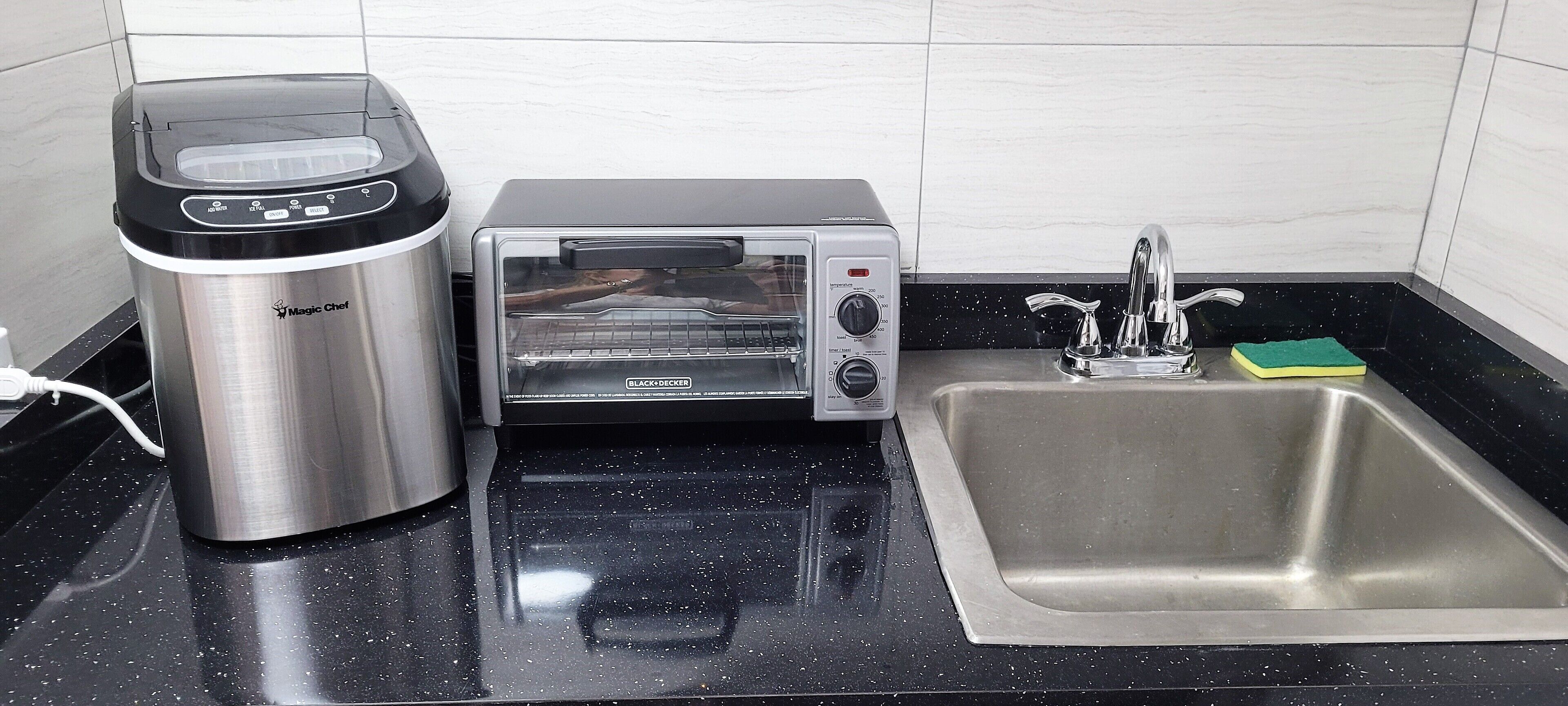 Een keuken met een koffiezetapparaat, een broodrooster en een spoelbak.