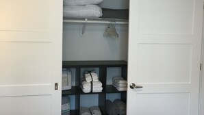 A bedroom with a bed, a closet with shelves, and a door. - Newly furnished 1 bed, steps to Boston's restaurants, museums, hospitals, Fenway (Boston)