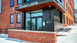 A modern building with a sign reading "Sunset Lofts" and "79 Parker Millat." - Newly furnished 1 bed, steps to Boston's restaurants, museums, hospitals, Fenway (Boston)