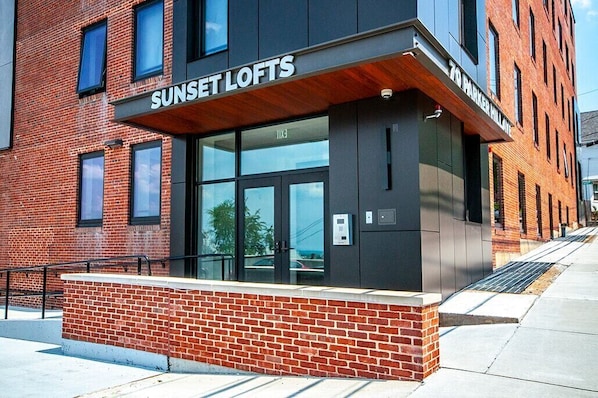 A modern building with a sign reading "Sunset Lofts" and "79 Parker Millat." - Newly furnished 1 bed, steps to Boston's restaurants, museums, hospitals, Fenway (Boston)