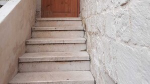 A narrow staircase leading to a wooden door with a metal handle. - Haifa Vintage Rooms (Haifa)