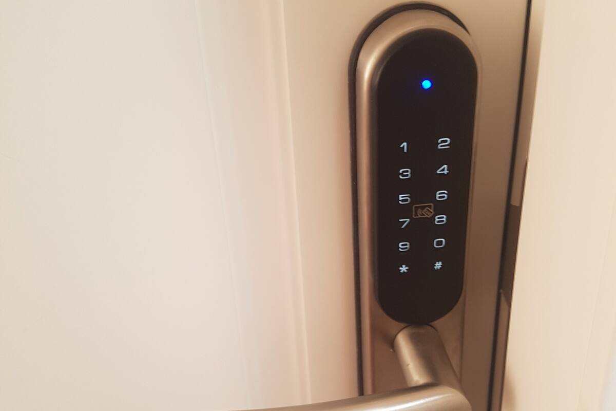 A door with a digital keypad lock and a metallic handle.