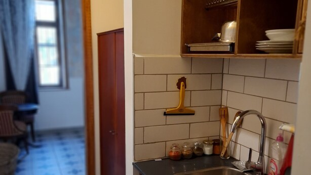 A compact kitchen with a sink, cabinets, and a window. - Haifa Vintage Rooms (Haifa)