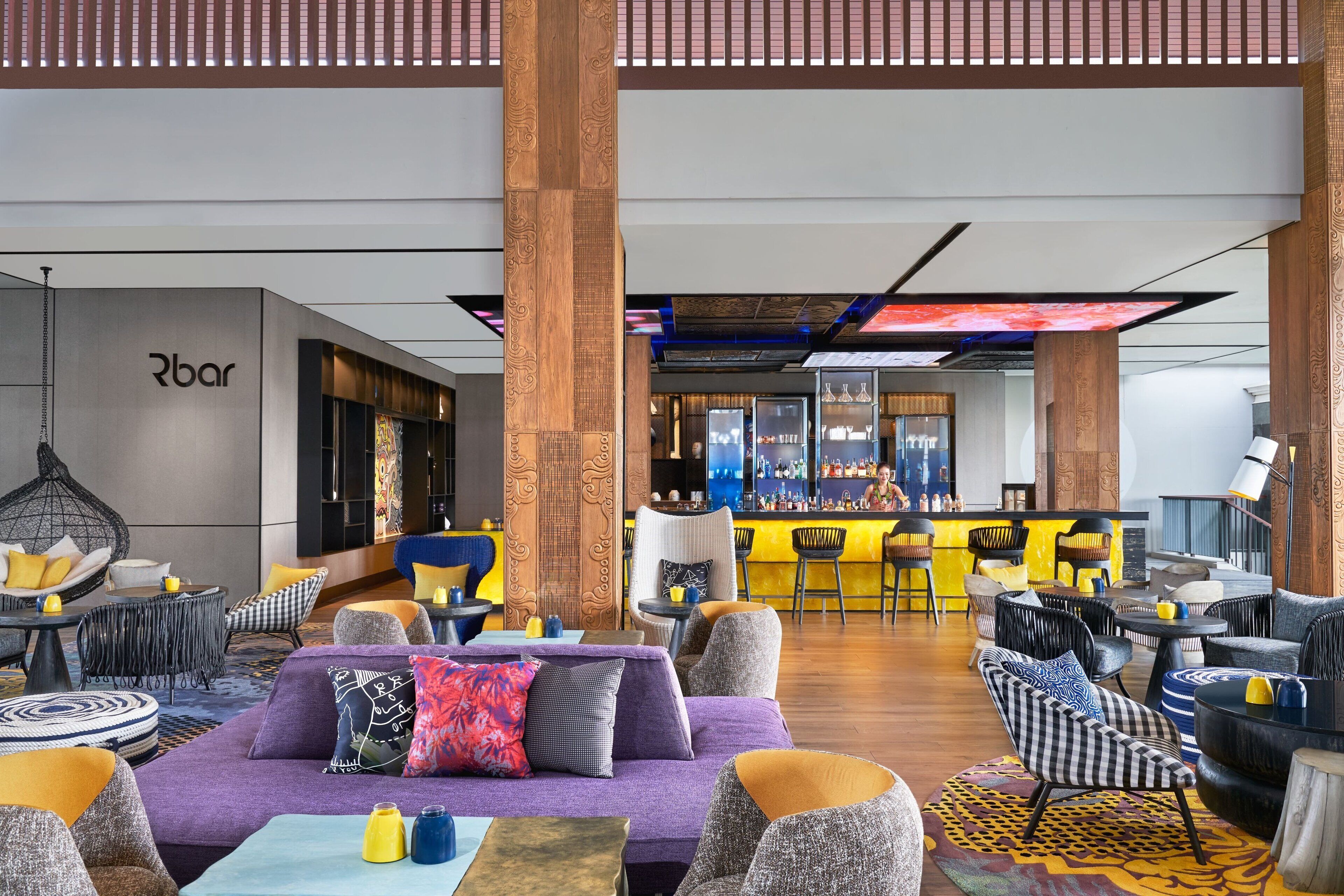 Uma área de estar moderna com sofás, cadeiras e um bar.