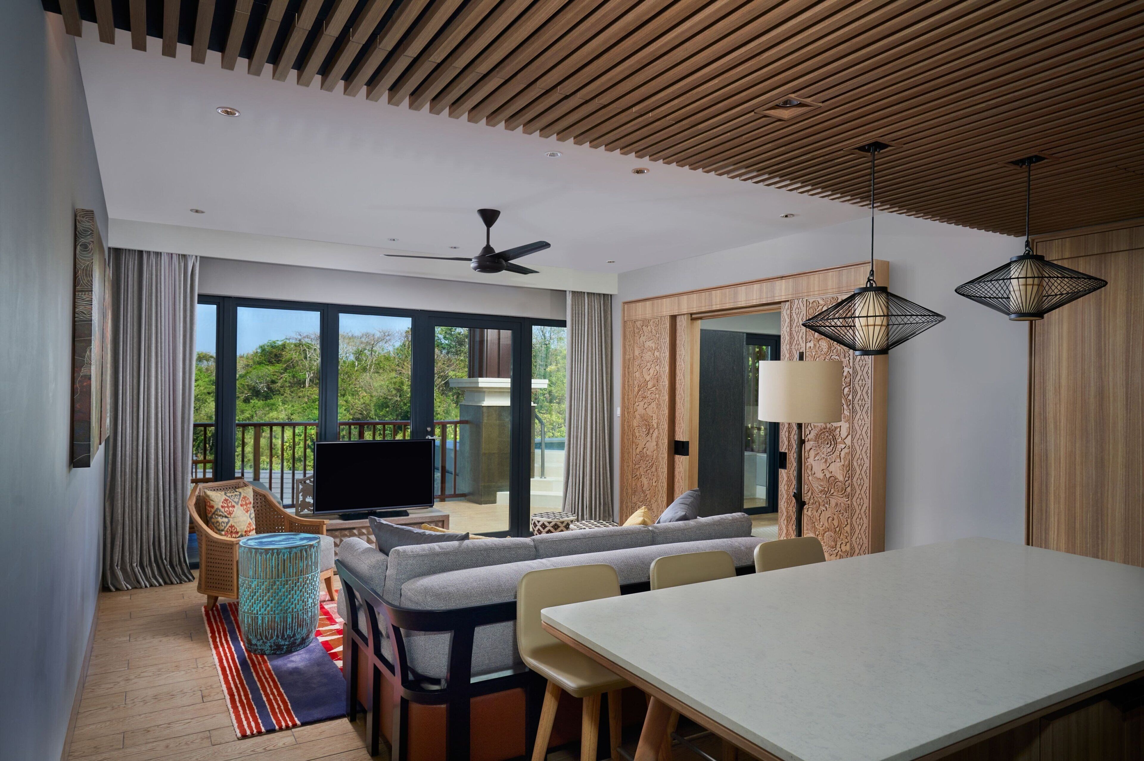 A modern living room with a sofa, TV, and dining table.