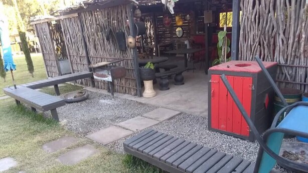 An outdoor seating area with a wooden deck, a red storage box, and a rustic fence. - Cabanas Ejido Santa Rosa Kilo78  Codigo 22766 (Santa Rosa)