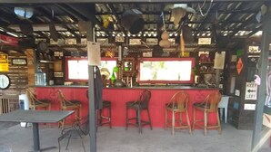 A restaurant with a bar area, tables, and chairs. - Cabanas Ejido Santa Rosa Kilo78  Codigo 22766 (Santa Rosa)