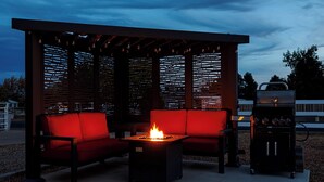 An outdoor seating area with a fire feature and a grill. - Modern Studio with Kitchen, Washer/Dryer, Fire Pit, Grill, & Red Rock Views! (Kanab)