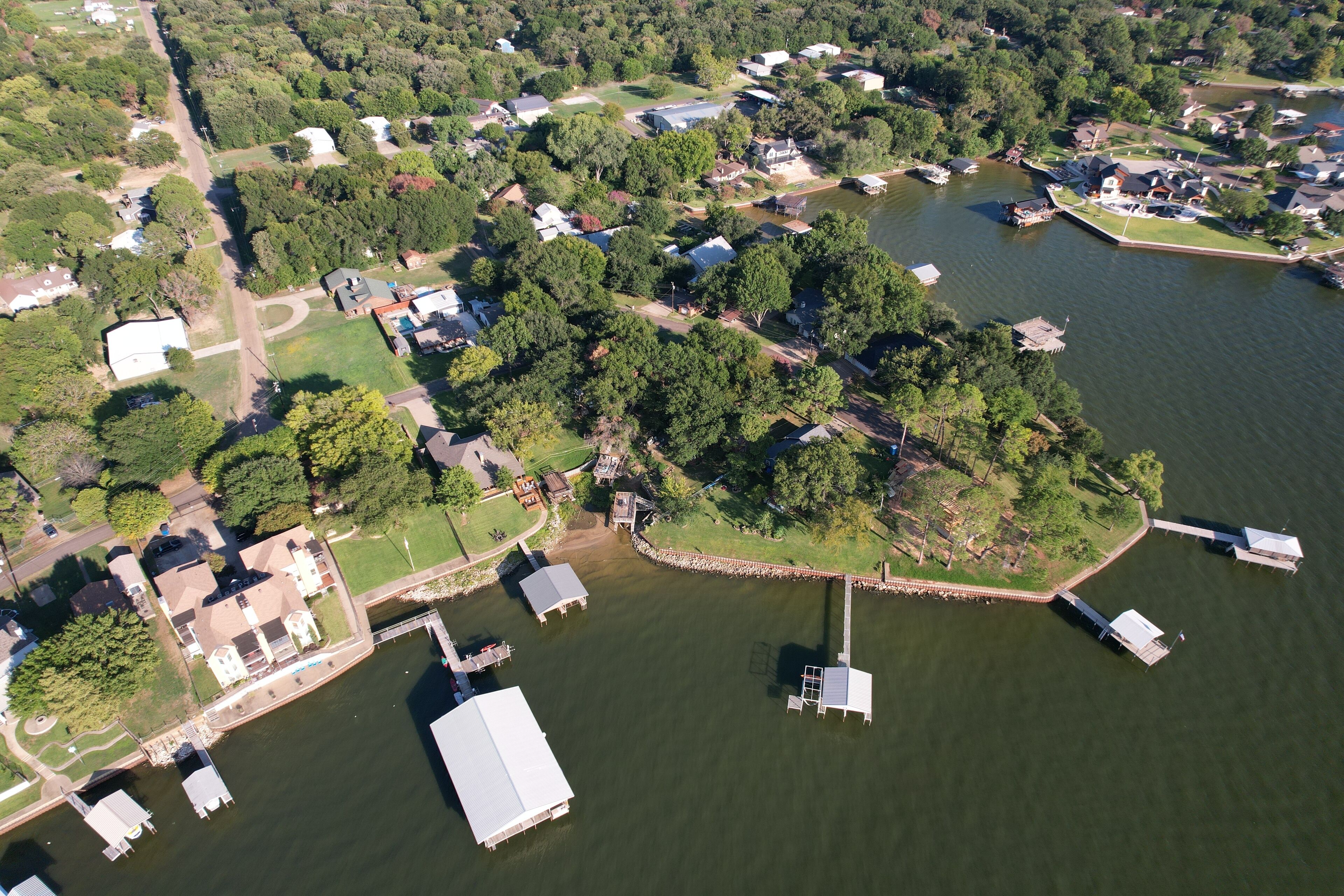 An aerial view of a lakeside community with houses, docks, and boats.
