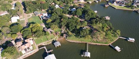 An aerial view of a lakeside community with houses, docks, and boats.