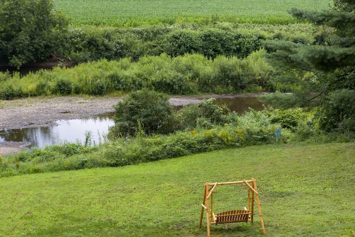 Eine grüne Wiese mit einer Holz-Schaukel.