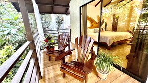 A balcony with wooden chairs and potted plants, overlooking a bedroom with a bed and a large window. - Private Bungalow-5min from Manuel Antonio beach (Quepos, Manuel Antonio)