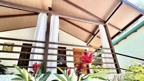 A covered outdoor area with a wooden structure, a stone wall, and lush green plants. - Private Bungalow-5min from Manuel Antonio beach (Quepos, Manuel Antonio)