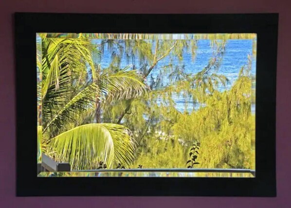 A framed picture of a tropical landscape with palm trees and water. - "Beyond" a paradise in Barbados (Cattlewash)