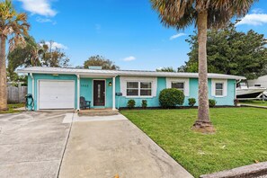 A single-story house with a garage, a front porch, and a lawn.