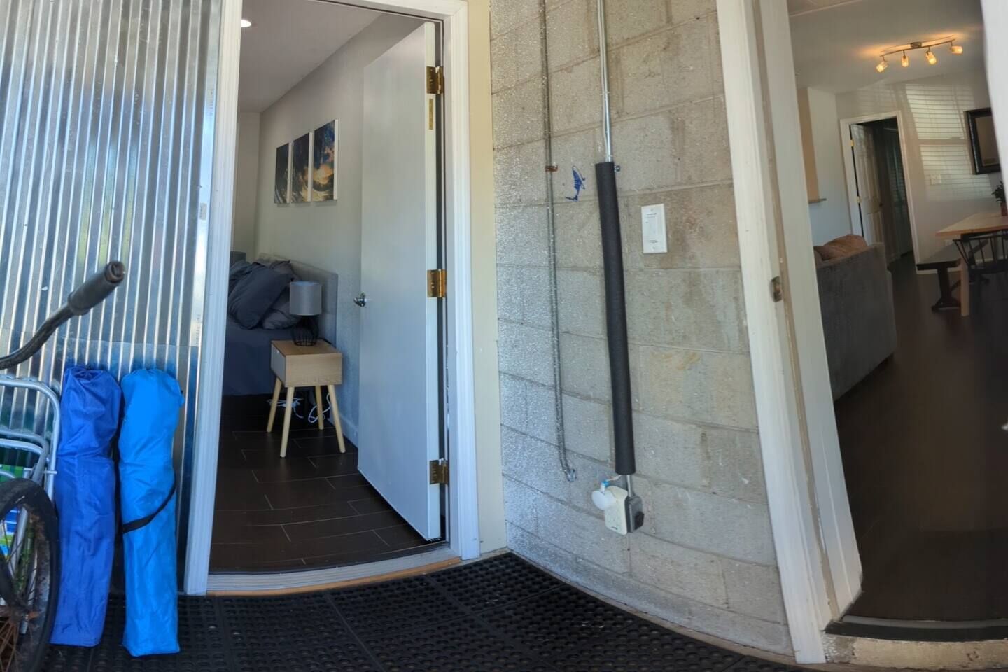A hotel entrance with a sliding door, a bicycle rack, and a small table with a lamp.